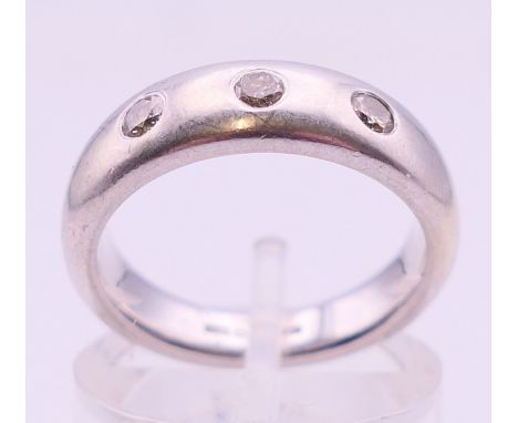 A 9 ct white gold three-stone diamond ring. Ring size K/L. 6.7 grammes.