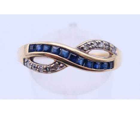 A 9 ct gold diamond and sapphire crossover ring. Ring size T/U.