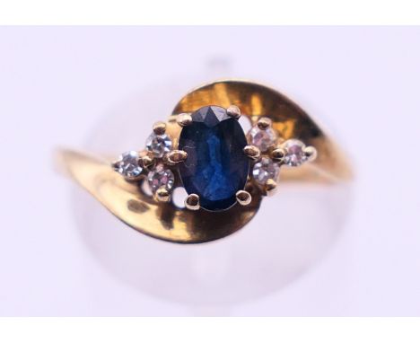 A 9 ct gold, diamond and sapphire crossover ring. Ring size O.