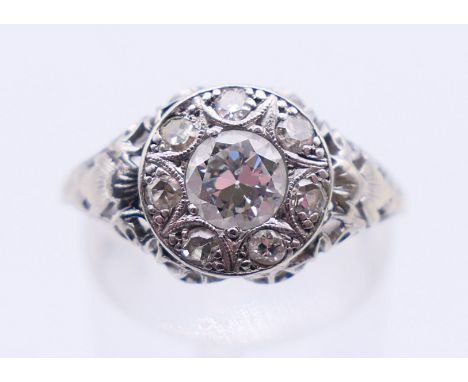 An 18 ct white gold and diamond ring. The central stone approximately 0.5 ct. Ring size N. 2.9 grammes total weight.