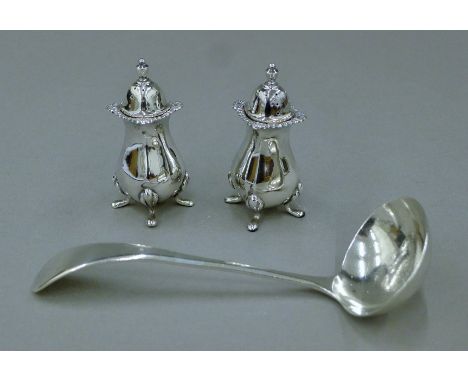 Two silver peppers and a silver ladle. The latter 15.5 cm long. 154.3 grammes.
