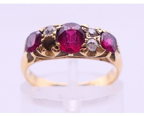 A gold (marks rubbed) diamond and ruby ring. Ring size K. 