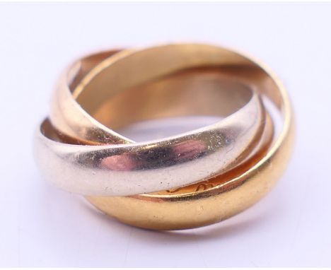 An 18 ct gold tri-colour Must de Cartier trinity ring.  Ring size E/F. 6 grammes.