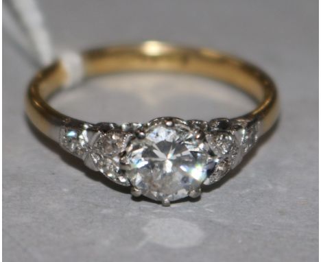 An 18ct gold and platinum, single stone diamond ring with diamond set shoulders, size O.