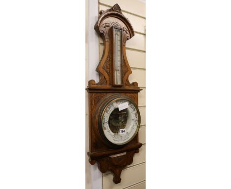 A carved oak barometer, W.28cm