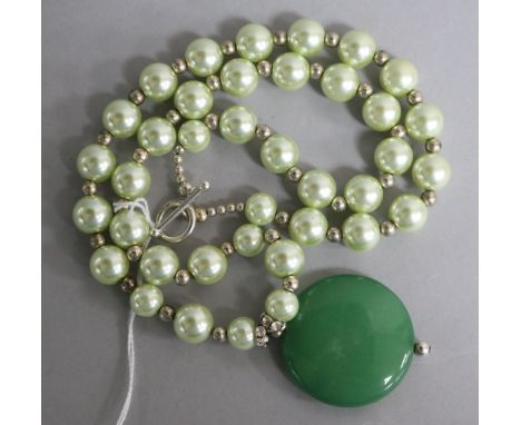 A jadeite disc pendant on a simulated pearl necklace, pendant 39mm.