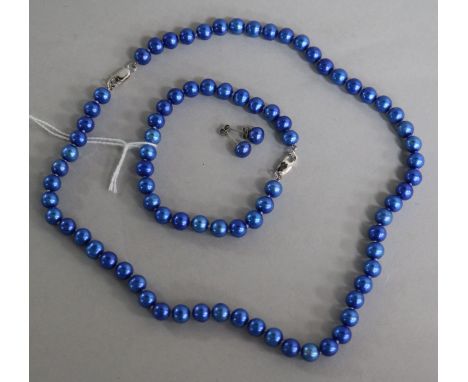 A single strand blue cultured pearl necklace, bracelet and pair of earrings.