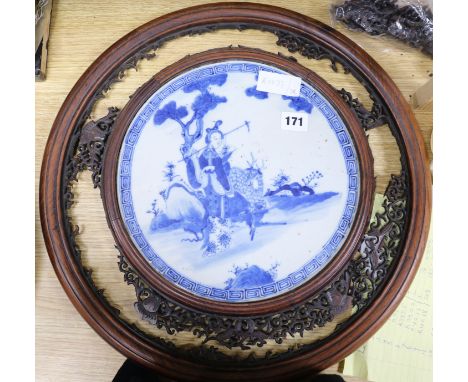 A carved blue and white Oriental screen inset with ceramic panel