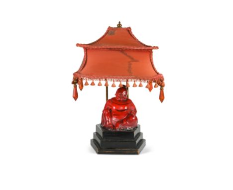 A rare Royal Doulton flambé model of The Smiling Buddha, circa 1925,designed by Charles Noke, mounted to an ebonised wood pli