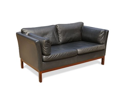 A Stouby style black leather two-seater sofa,raised on square section legs 70 x 143 x 76cmCondition report: slightly sun-fade