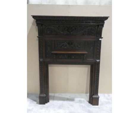 A heavily carved oak mantelpiece decorated with mythical figures, faces etc, small mantel shelf, 145cm by 30cm by 195cm 