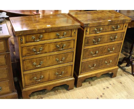 Bevan Funnell Reprodux, a pair of yew bachelors chests each having fold tops above four drawers on shaped bracket feet