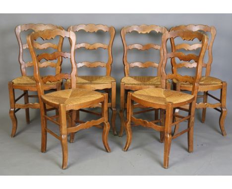 A set of six late 20th century French walnut ladder back dining chairs with rush seats, on cabriole legs united by stretchers