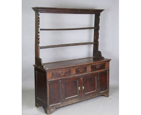 An 18th century oak dresser, the later shelf back with a moulded pediment, the base fitted with three drawers and a pair of p