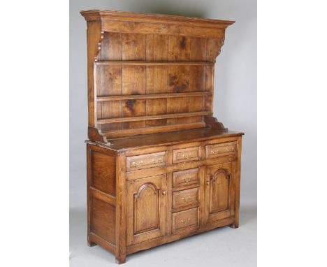 A 20th century George III provincial style solid oak dresser, the shelf back above drawers and cupboards, height 193cm, width