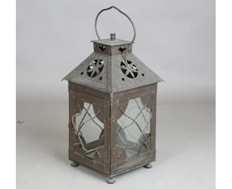 A late 19th century Arts and Crafts patinated copper hanging lantern, the pierced hood enclosing a three-branch light fitting