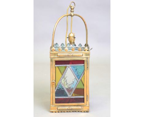 An early 20th century gilt metal square hall lantern, the sides inset with stained glass panels, height 50cm.Buyer’s Premium 