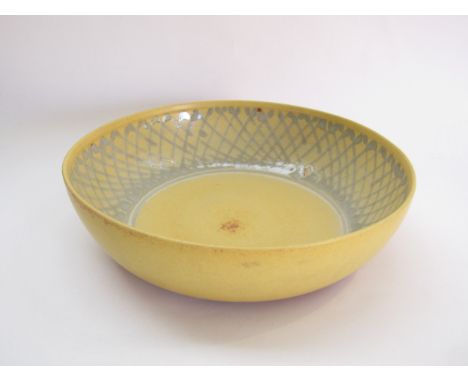 DAVID LLOYD-JONES (1928-1994) A large studio pottery bowl with yellow glaze and a blue crossed line border to interior. Impre