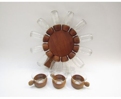 A revolving teak spice rack,  39cm diameter with 12 spice pots in clear glass and three wood and glass cups, "Schott" glas 