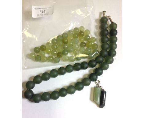 One dark beaded Jade necklace, two Jade pendants and a quantity of Jade beads. (4)