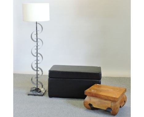 A black upholstered ottoman, together with a hardwood side table and a modern standard lamp and shade, 147cm tall