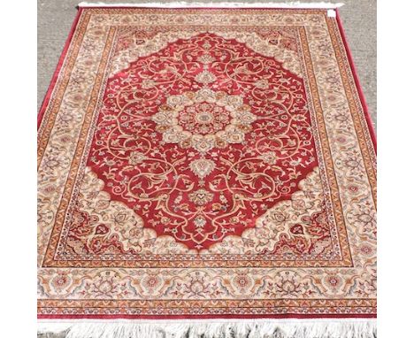 A Keshan carpet, with a central medallion and floral designs, on a red ground, 230 x 160cm 