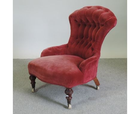 A Victorian red upholstered button back armchair, on turned legs