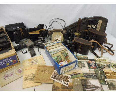 A quantity of collectables to include cameras, cigarette cards, postcards, binoculars, a bell-metal school bell and a loud sp