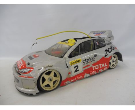 A Peugeot 206 Rally Monte Carlo Pro remote controlled car on a rare Reely/Verbrenner P190 German 4WD chassis with a nitro eng