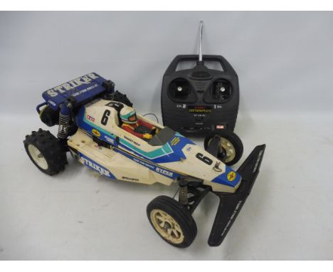 A Tamiya Striker 58061 1/10th scale electric remote controlled buggy circa 1987, plastic tub and body plus an Acoms Techniplu