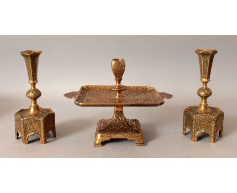 A PAIR OF EARLY 20TH CENTURY PERSIAN ENGRAVED BRASS CANDLESTICKS, with black inlay ground, 7.4in high; together with a simila