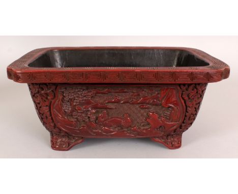 A GOOD 19TH/20TH CENTURY CHINESE RED CINNABAR LACQUER RECTANGULAR JARDINIERE, with indented corners, the sides carved with pa