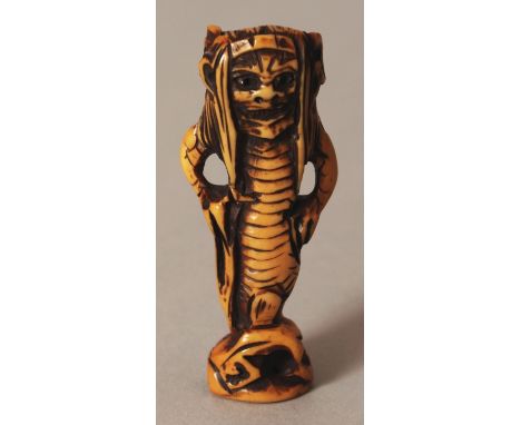 AN UNUSUAL SIGNED JAPANESE MEIJI PERIOD STAINED IVORY NETSUKE OF AN ONI SEA CREATURE, with demonic features, the base with an