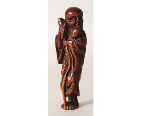 A GOOD JAPANESE EDO/MEIJI PERIOD CARVED WOOD NETSUKE OF A STANDING SENNIN, the bearded sage leaning on a curved staff, 3.9in 