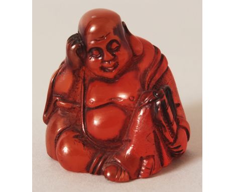A SIGNED JAPANESE AMBER-LIKE NETSUKE OF HOTEI, seated and holding a fan, the base with an engraved signature, 1.75in high.