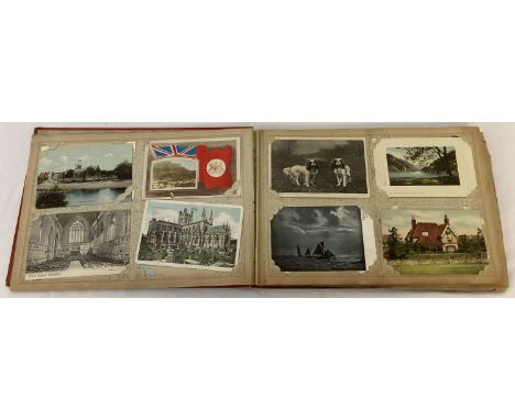 A vintage red postcard album containing approx. 100 assorted vintage postcards.