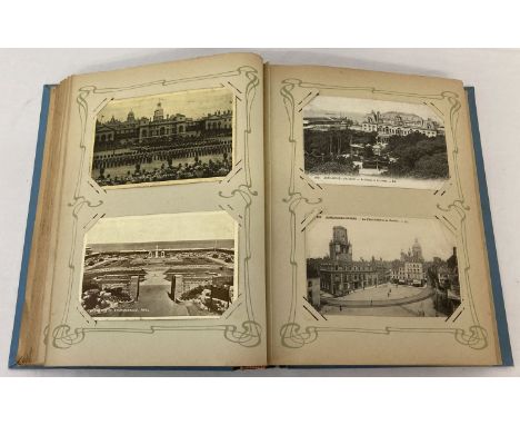 A vintage blue Art Nouveau postcard album containing a quantity of cards. To include: greetings cards, British street scenes 