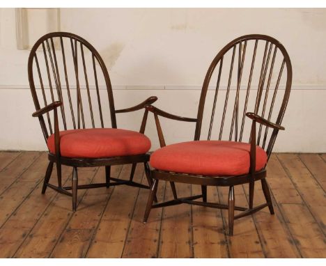 A pair of Ercol dark elm stick back Windsor type armchairs, each having a red seat cushion70w x 63d x 102h cm