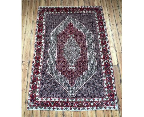A Persian Senneh carpet, having a central hooked medallion on a patterned ground290 x 200cm