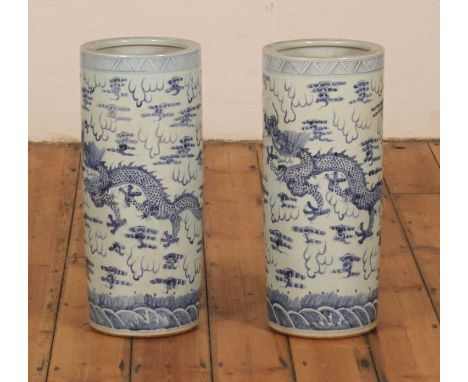 A pair of Chinese blue and white porcelain cylindrical vases or walking stick stands, each decorated with a dragon (2)26w x 6