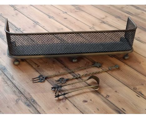A brass fire fender, 87cm, with brass firetools