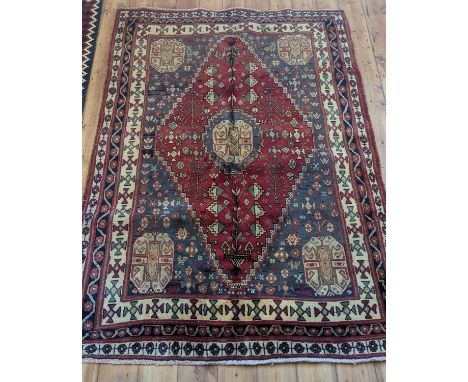 A Persian Qashgai rug, having a central diamond, on a red ground230 x 168cm