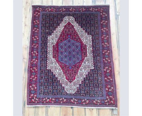 A Persian Senneh rug, having a large ivory medallion, on a geometric ground150 x 123cm