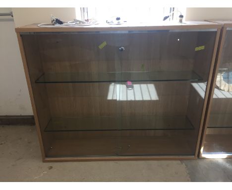 A beech effect wall mountable display cabinet with sliding glass panel front. With 2 internal glass shelves and lighting. Mea