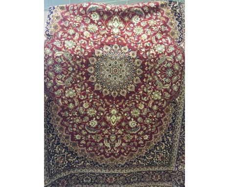 A large Keshan ground carpet of red colouration. With black brown and beige design to outside. Approx 280 x 200cm. 