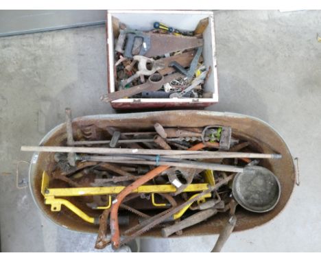 A collection of old tools to include garden implements, saws and a variety of hand tools. 