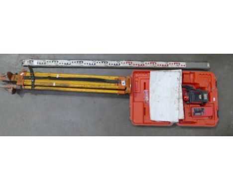 A laser level together with a wooden tripod base. (2)