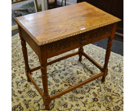 A mid 20th century light oak hall table, one long drawer to frieze carved green man handle, turned tapering supports, refecto