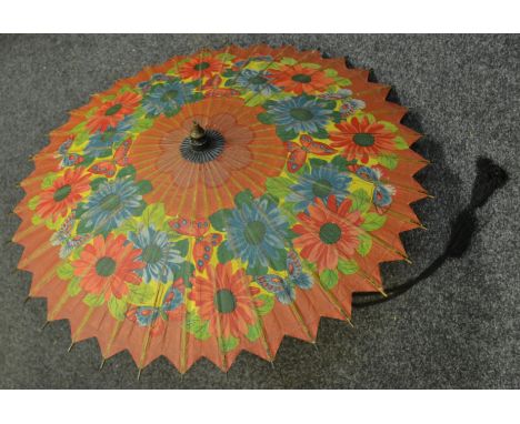 A Japanese lady's parasol, paper blades printed with colourful flowers and butterflies with bamboo stick and turned softwood 