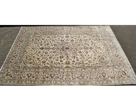 A Kashan carpet, the madder field with floral motifs, on a cream ground, 345cm x 250cm